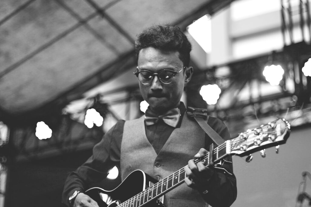Un homme en train de jouer de la guitare sur scène.