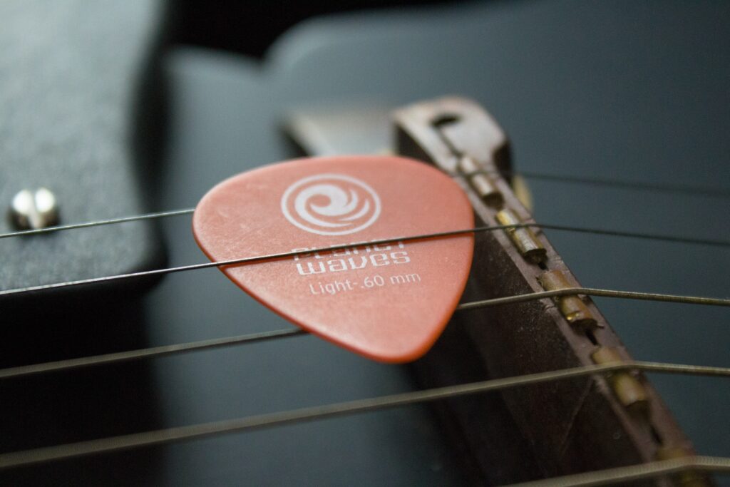 Rangement du médiator de guitare sur l'instrument.