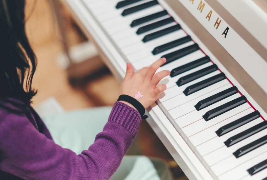 Une fille travaille son piano en cours de musique.
