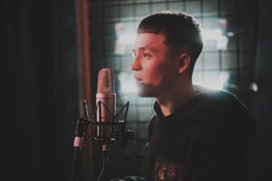 Un chanteur enregistre sa voix dans un studio.