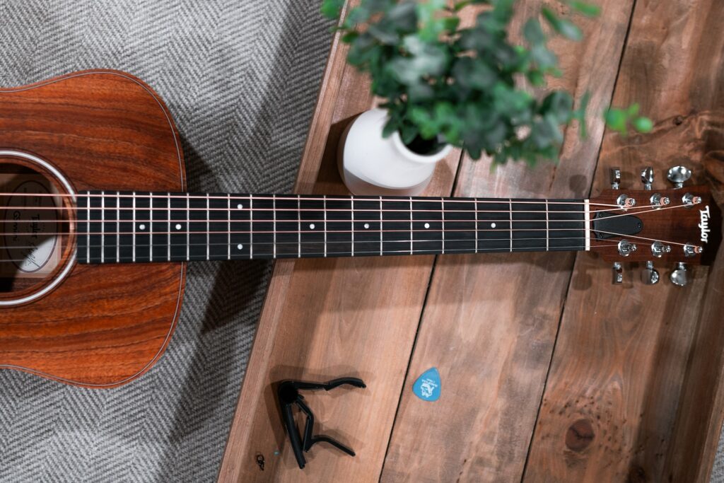 Une guitare posée sur une table en bois avec des accessoires.