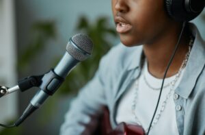 Une femme chante avec une guitare.