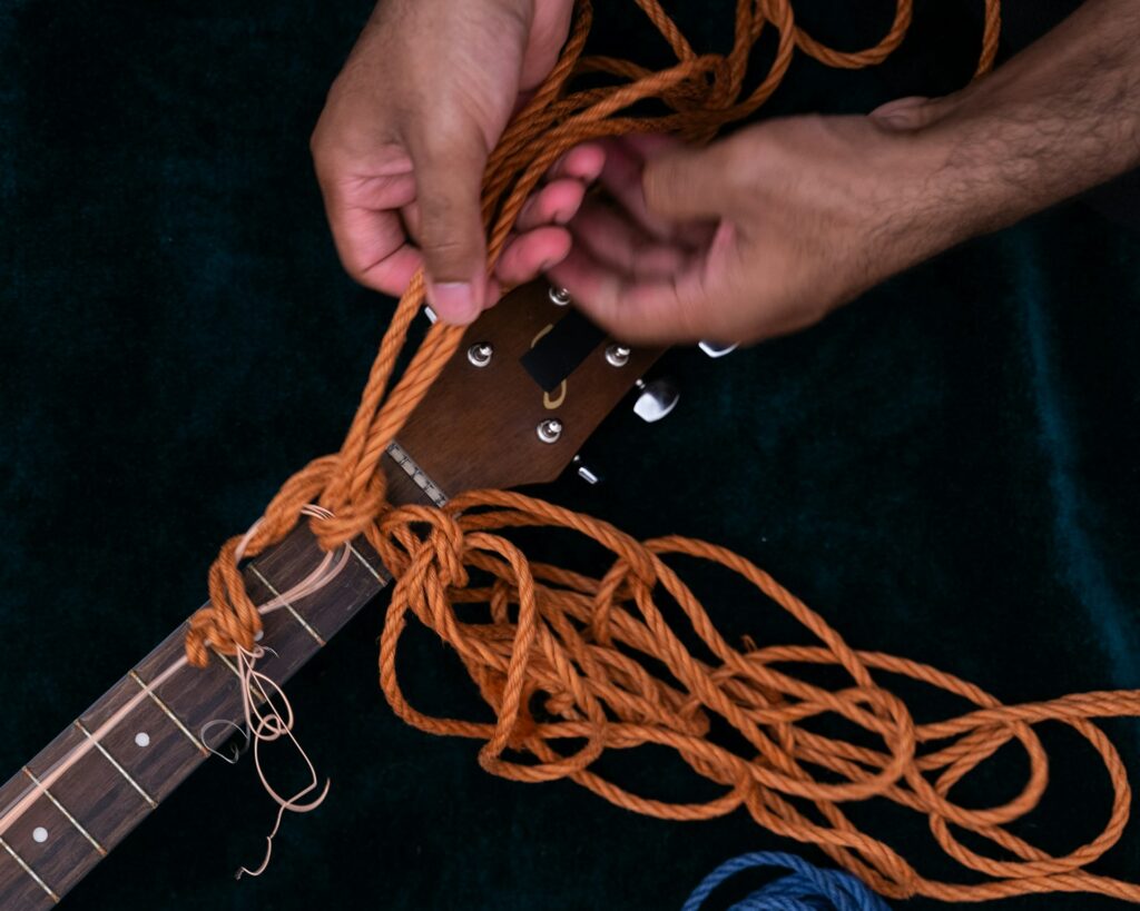 Une guitare attachée avec une corde orange.