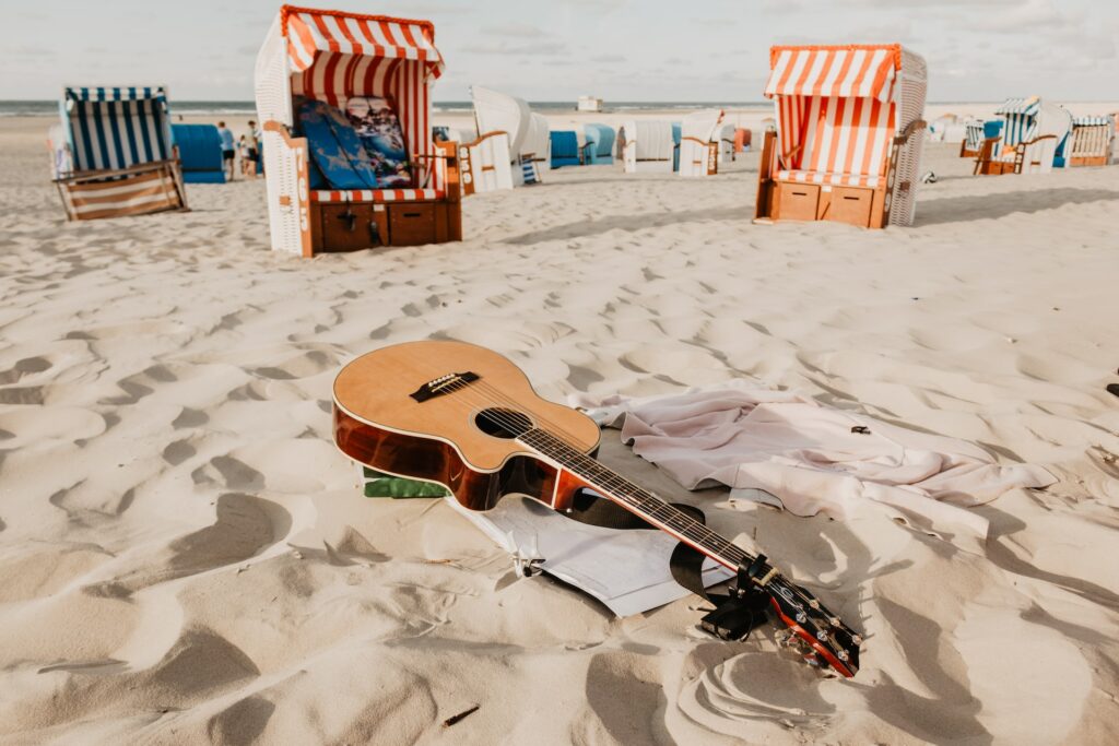 Une guitare posée au sol sur la plage, sans protection.