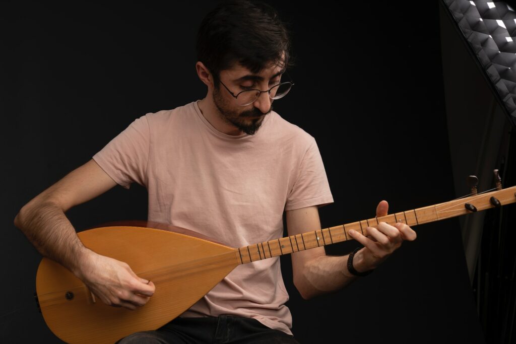 Un musicien joue de la mandoline sur un fond noir.