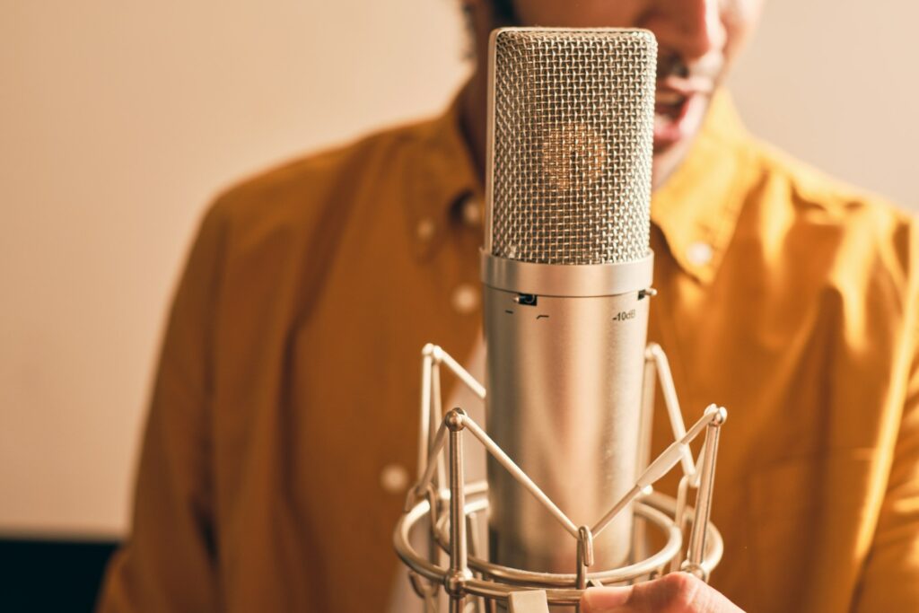 Un artiste s'enregistre en chantant dans un microphone.