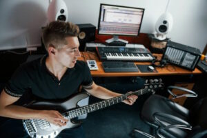 Un guitariste s'entraîne dans sa maison transformée un studio d'enregistrement.