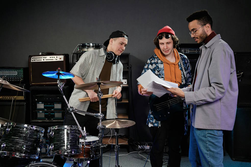 Des membres d'un groupe de musique lisent une feuille de papier devant leurs instruments.