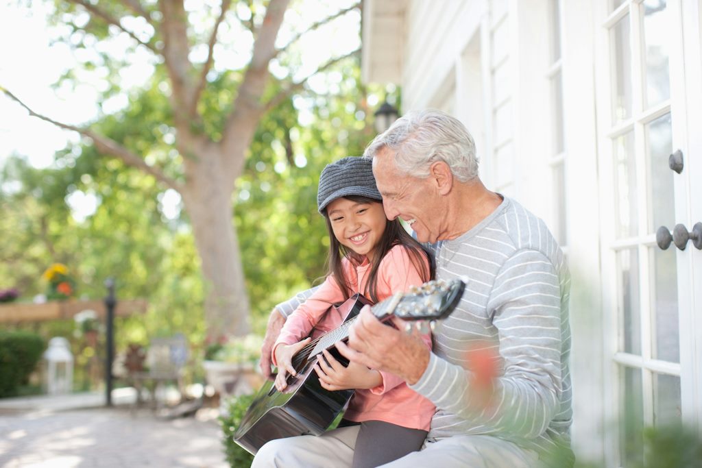 Un vieil homme avec sa petite-fille jouent dans la rue de la guitare.