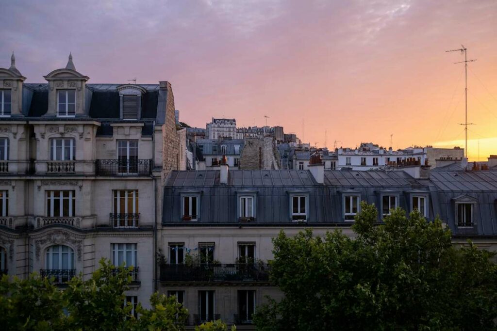 Vue sur les toitures des immeubles parisiens au coucher du soleil.
