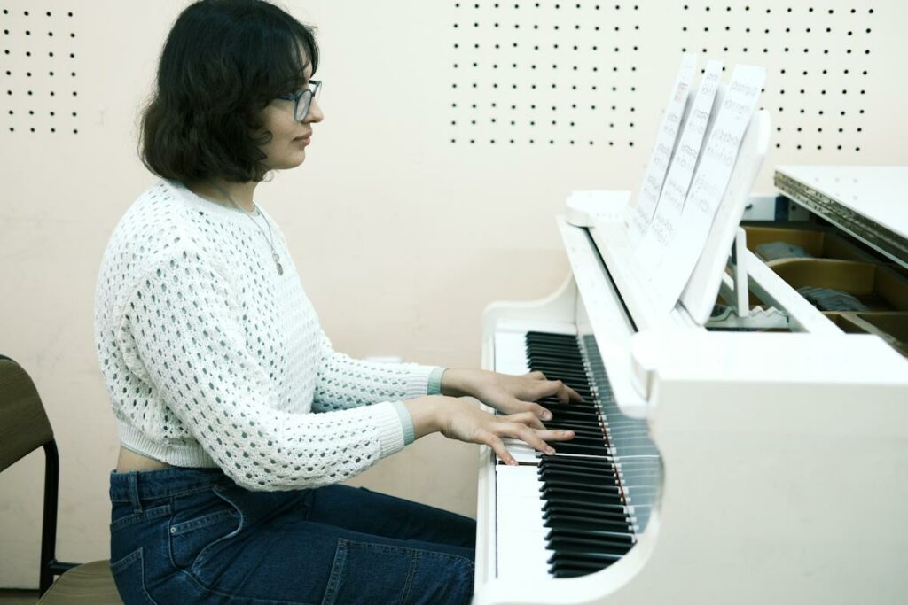 Une femme fait du piano en s'aidant d'une partition.