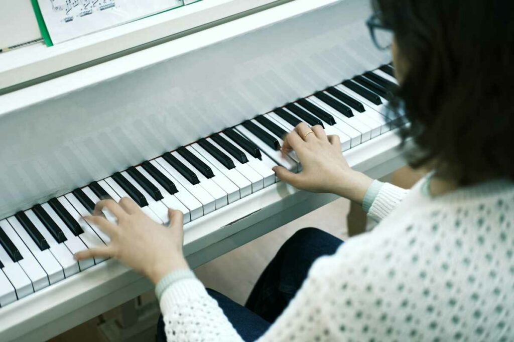 Une femme joue au piano avec ses deux mains.