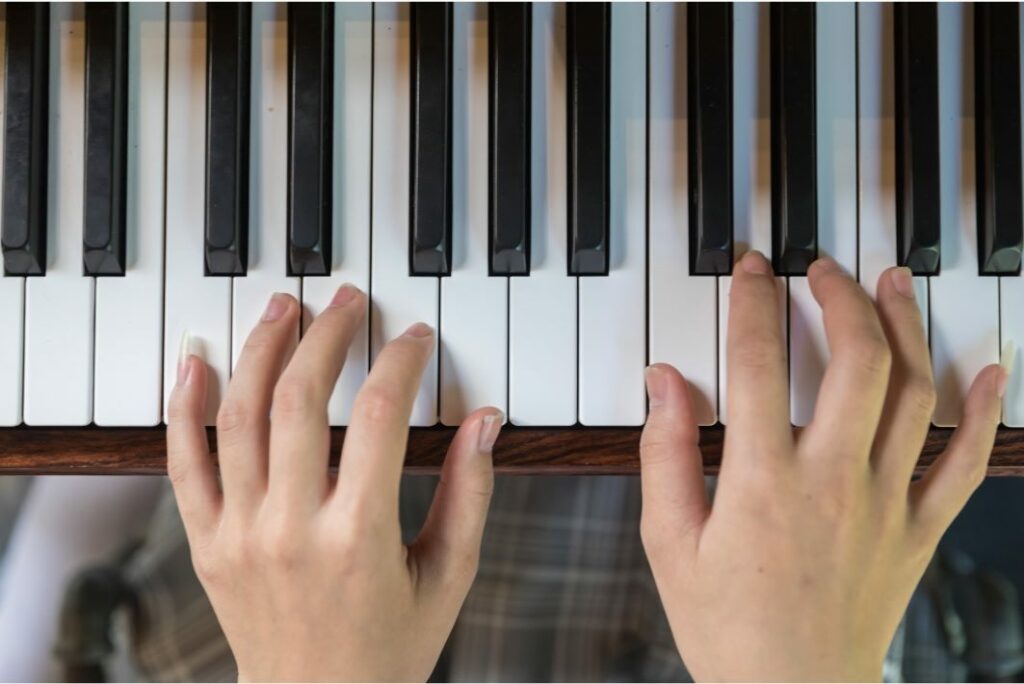 Deux mains posées sur les touches d'un piano.