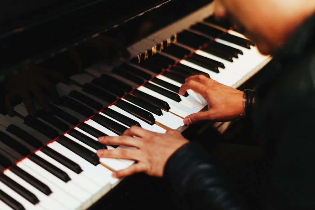 Un musicien répète avec deux mains sur un piano.