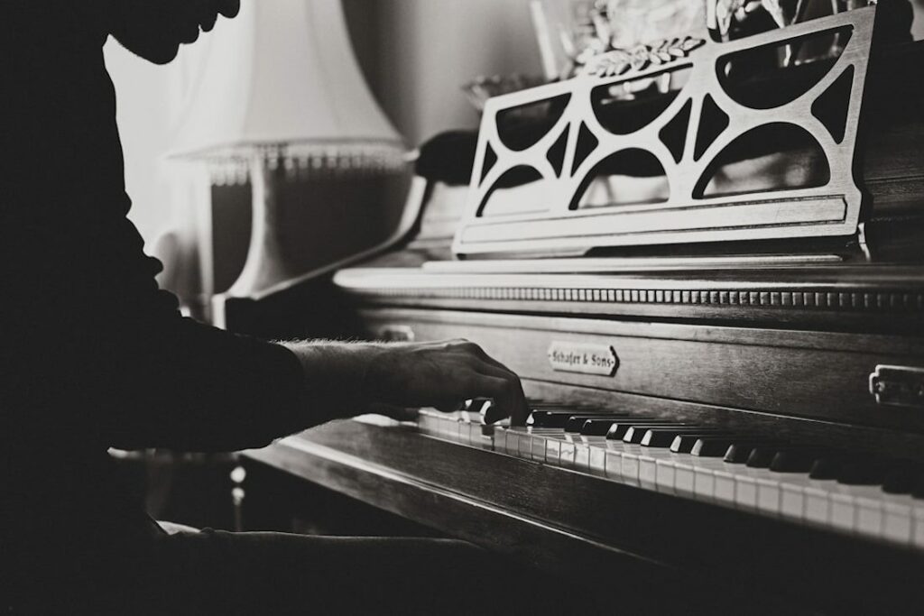 Vue de profil d'un pianiste en train de faire un morceau à deux mains.