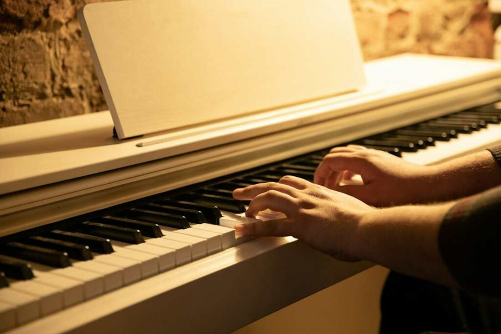 Un homme photographié de profil en train de jouer du piano.