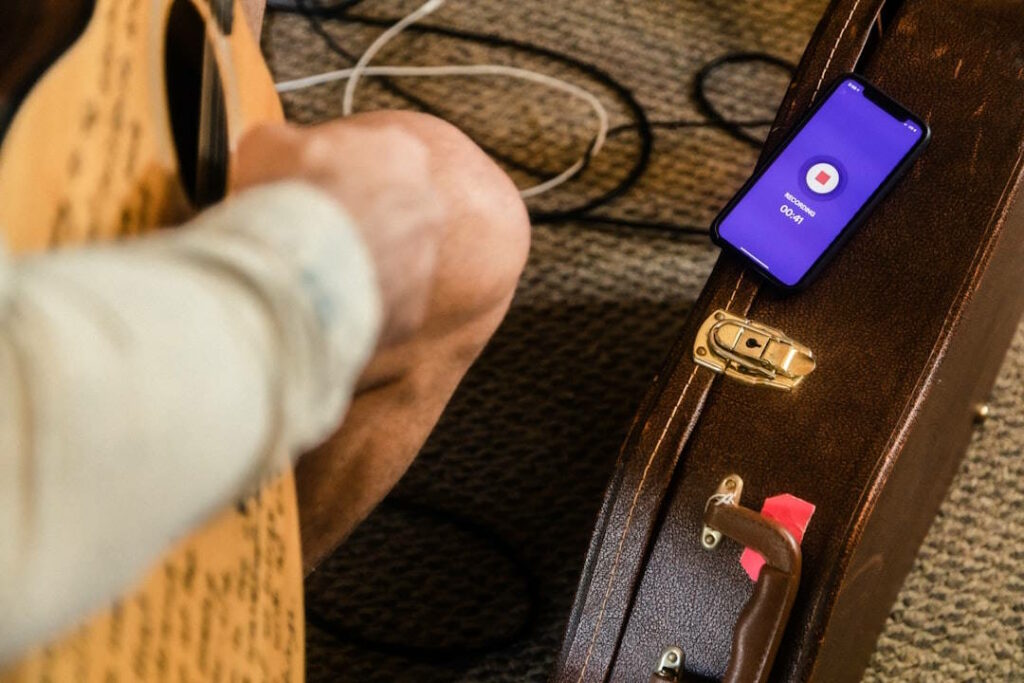 Un homme s'enregistre en jouant de la guitare.