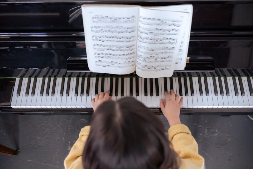 Une jeune femme vue de haut en train de jouer du piano.