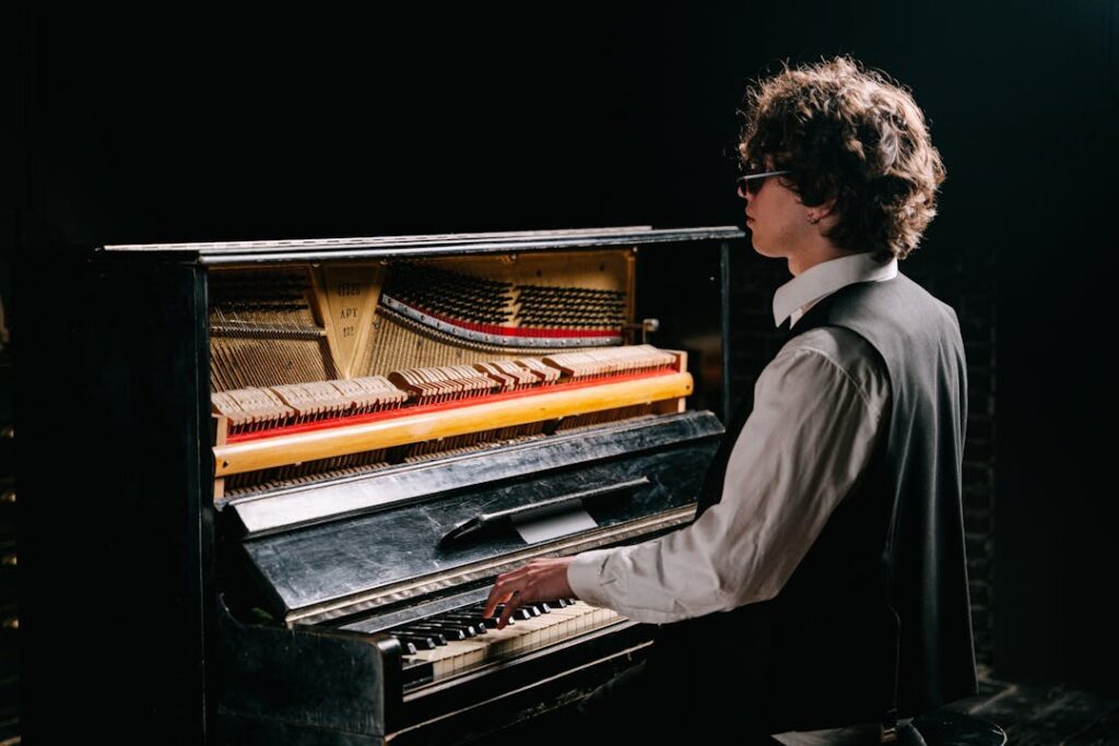 Un pianiste photographié de dos, en train de jouer du piano.