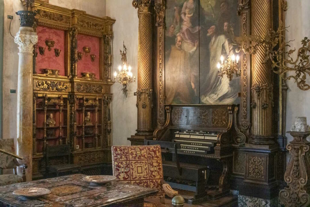 Un très vieux piano droit installé dans une pièce ressemblant à un château.