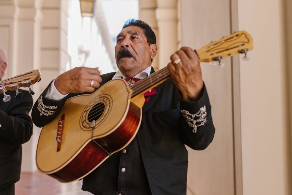 Un vieil homme en train de jouer de la guitare en position debout.