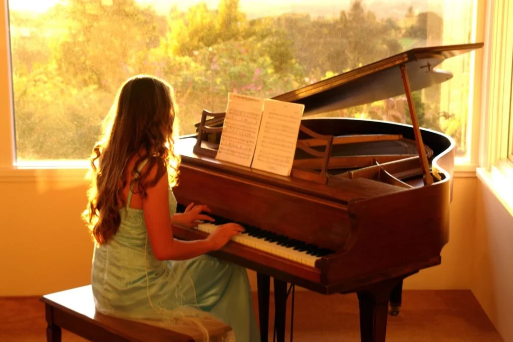 Une jeune fille joue sur un piano de concert.