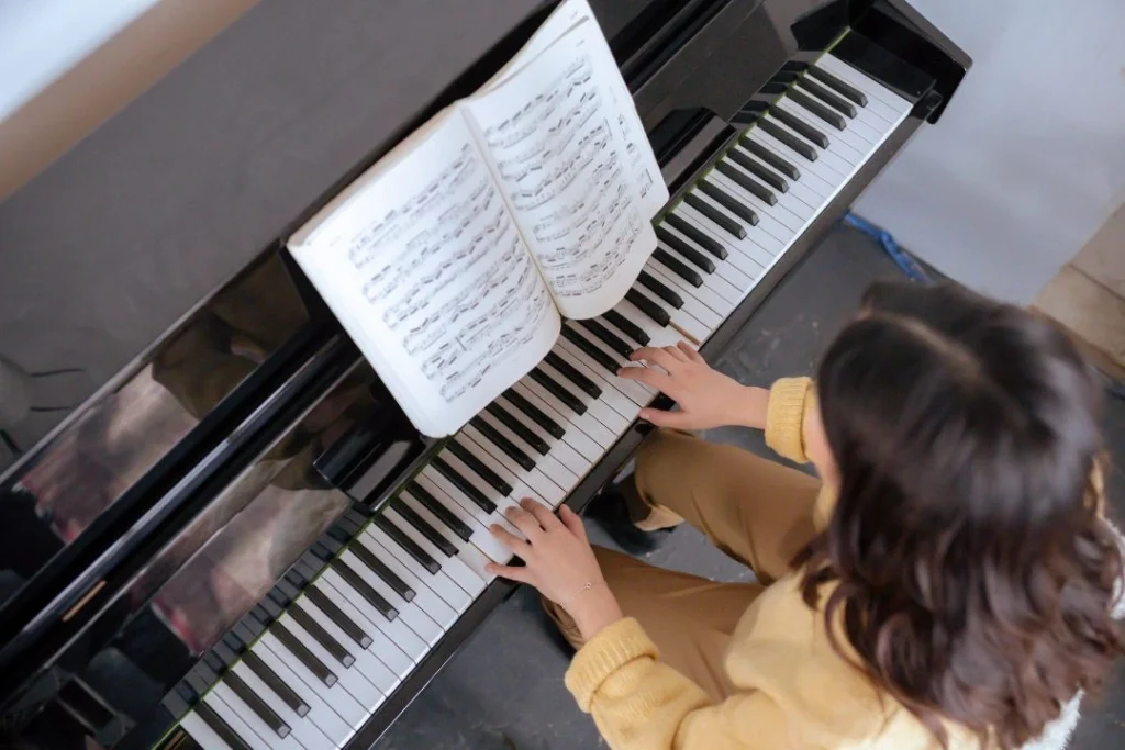 Une fille vue de dessus joue du piano.