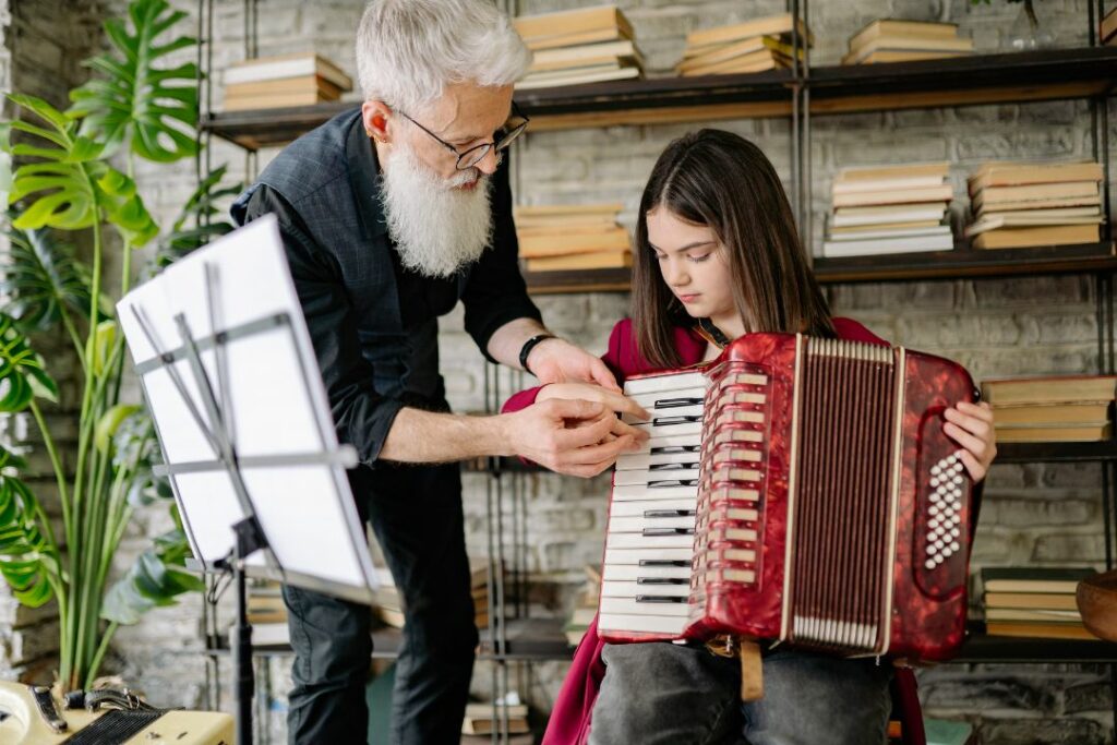 Une jeune fille qui joue de l'accordéon avec son professeur particulier.