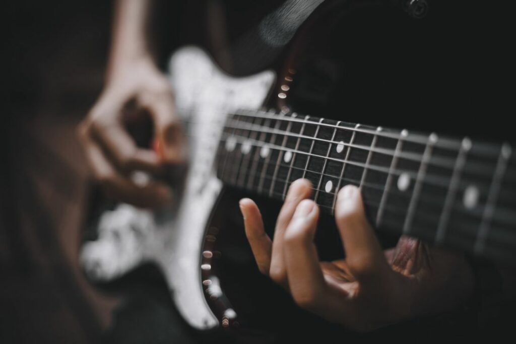 Une personne en train de jouer de la guitare électrique.