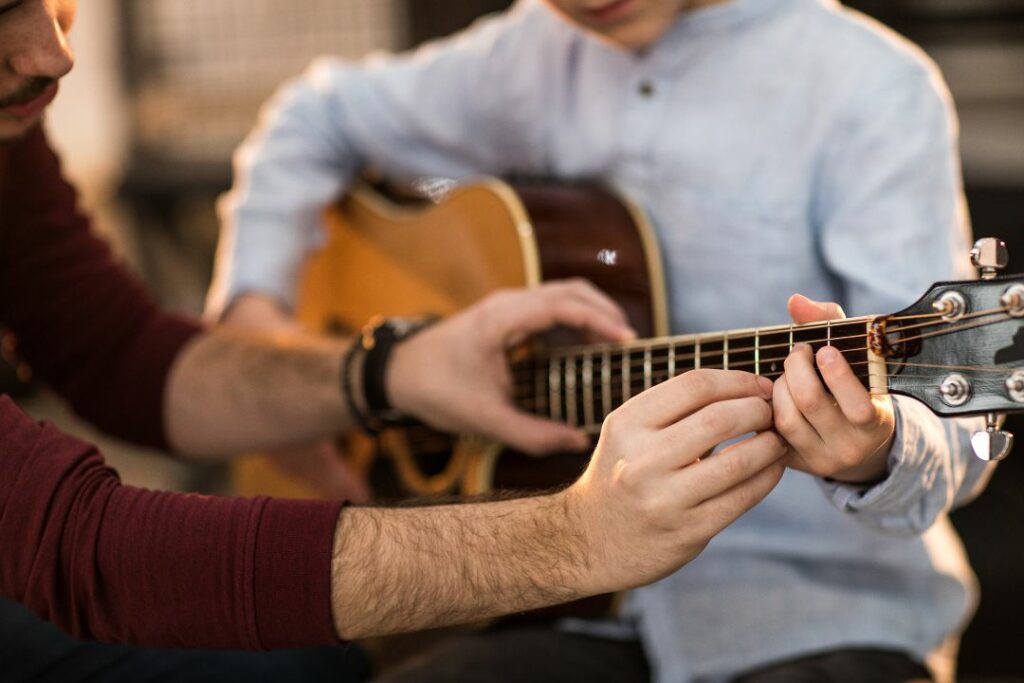 Un cours de guitare pour un enfant.
