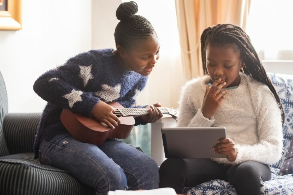 Deux jeunes filles apprenant la guitare.