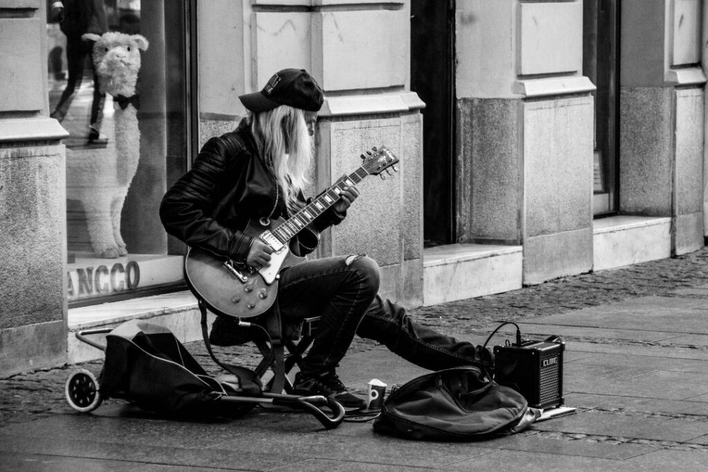 Un homme en train de jouer de la guitare dans la rue.