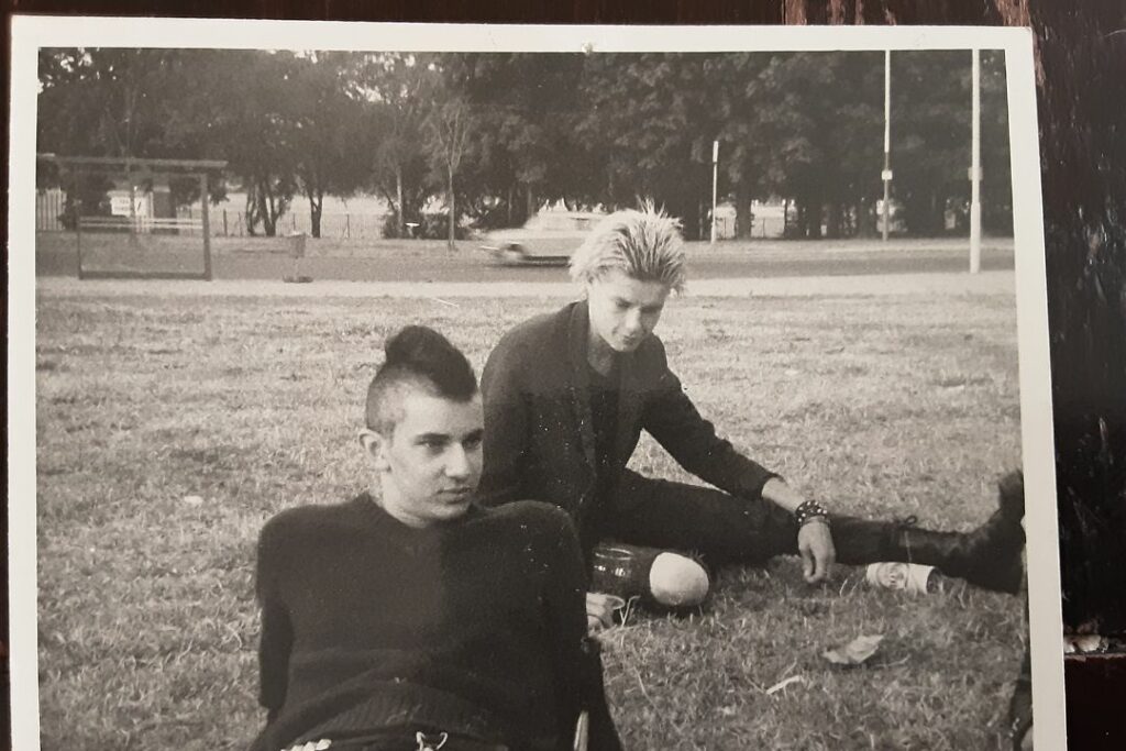Deux personnes au genre punk assises sur une pelouse.