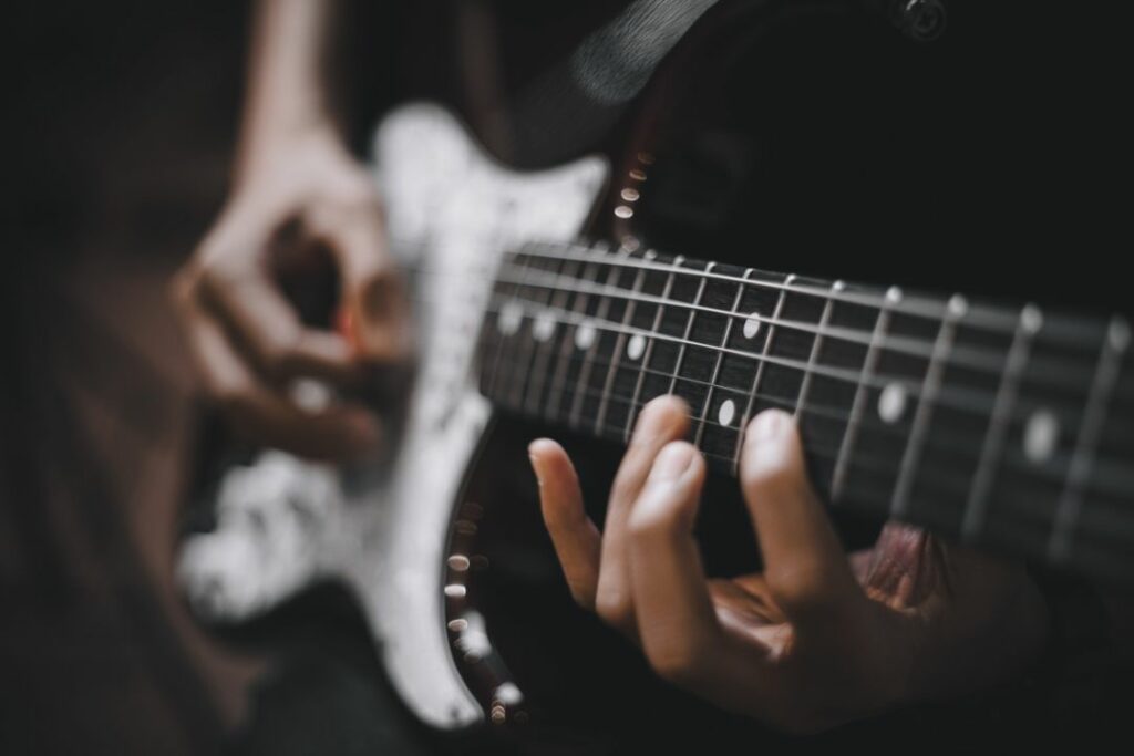 Un guitariste est en train de jouer de la guitare électrique.